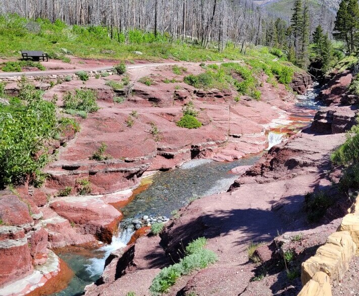 Canyon in the mountains with red cliffs and a river at the bottom